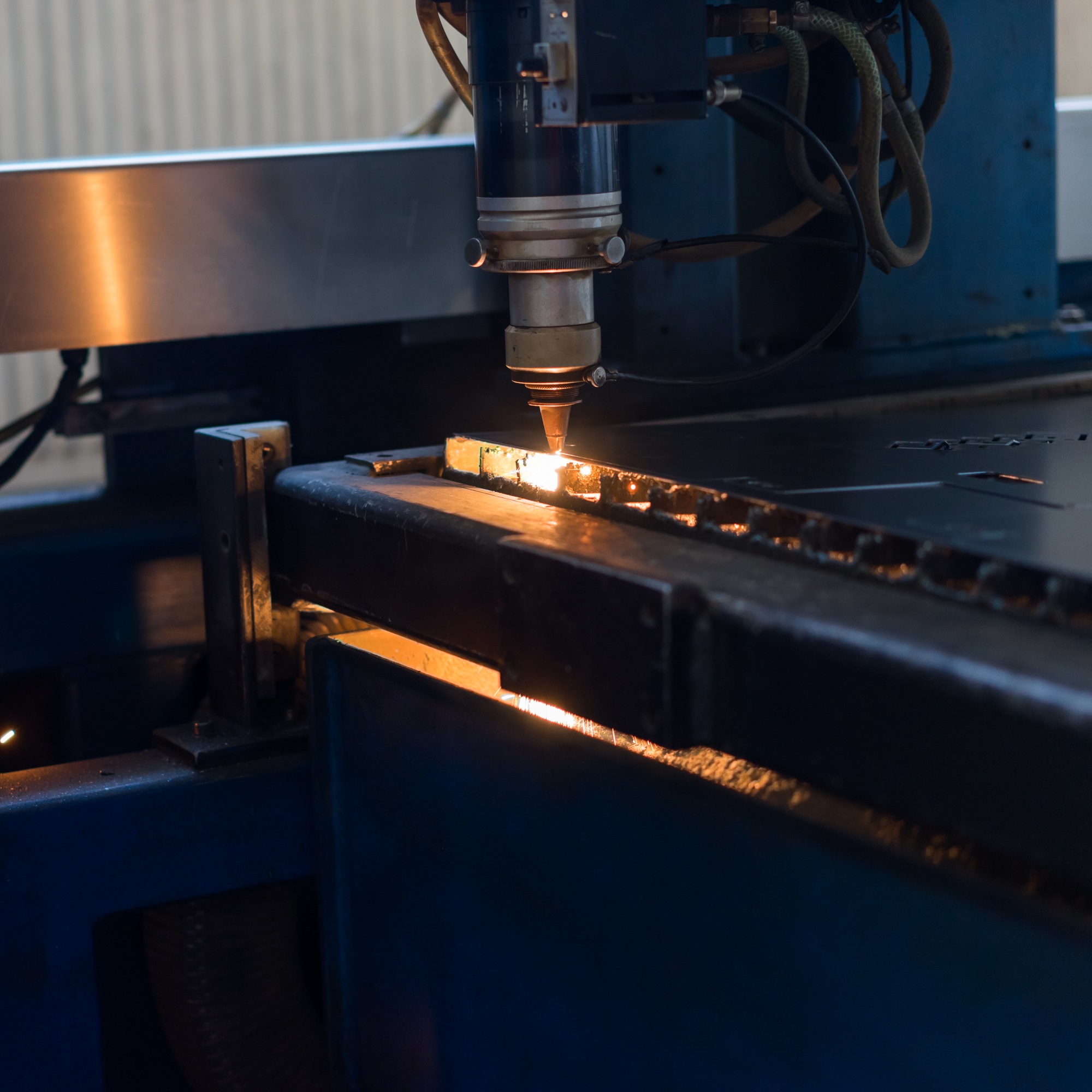 laser head cutting patterns into metal sheets