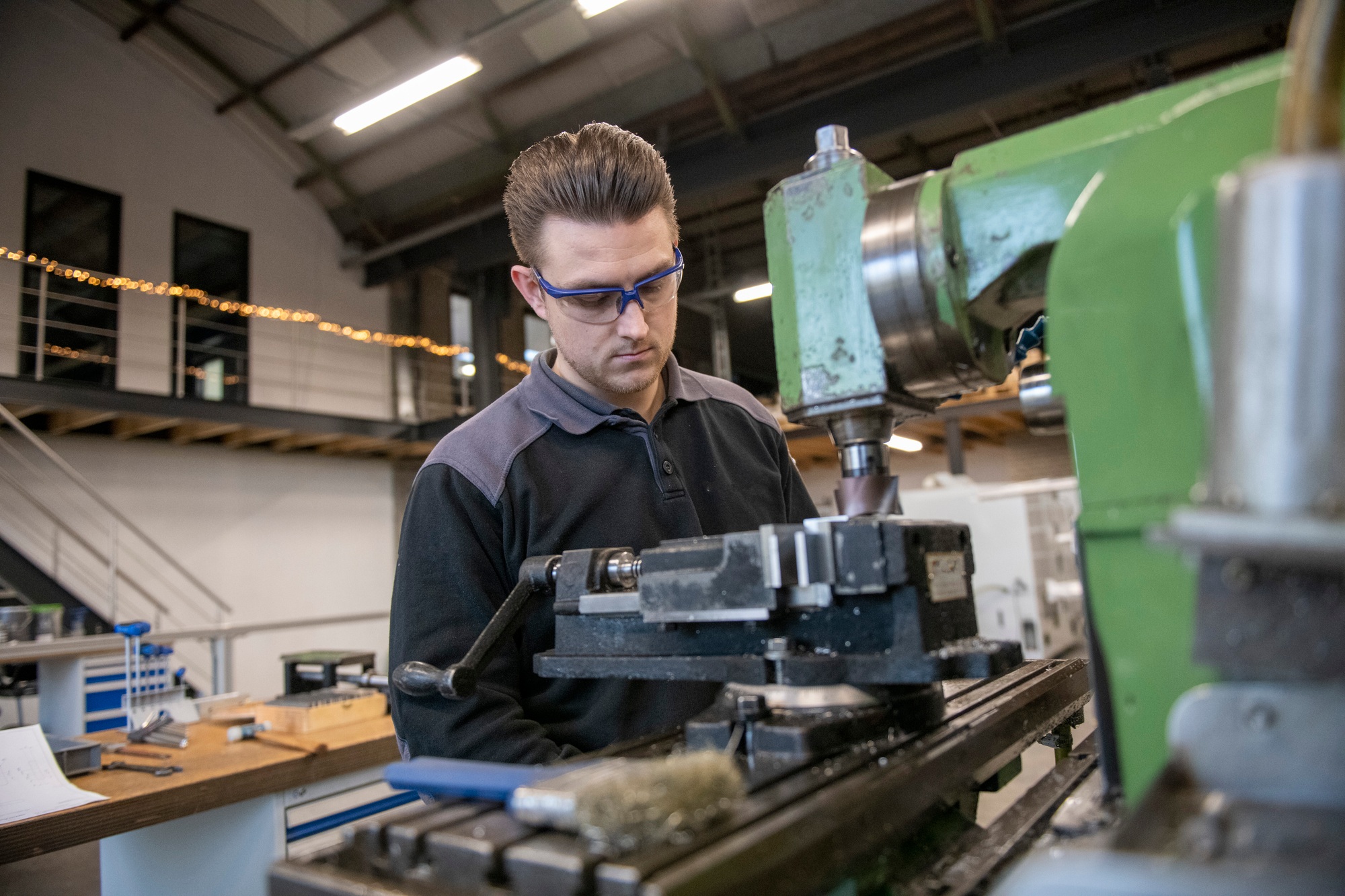 Young mechanical engineer working on steel machinery in a factory